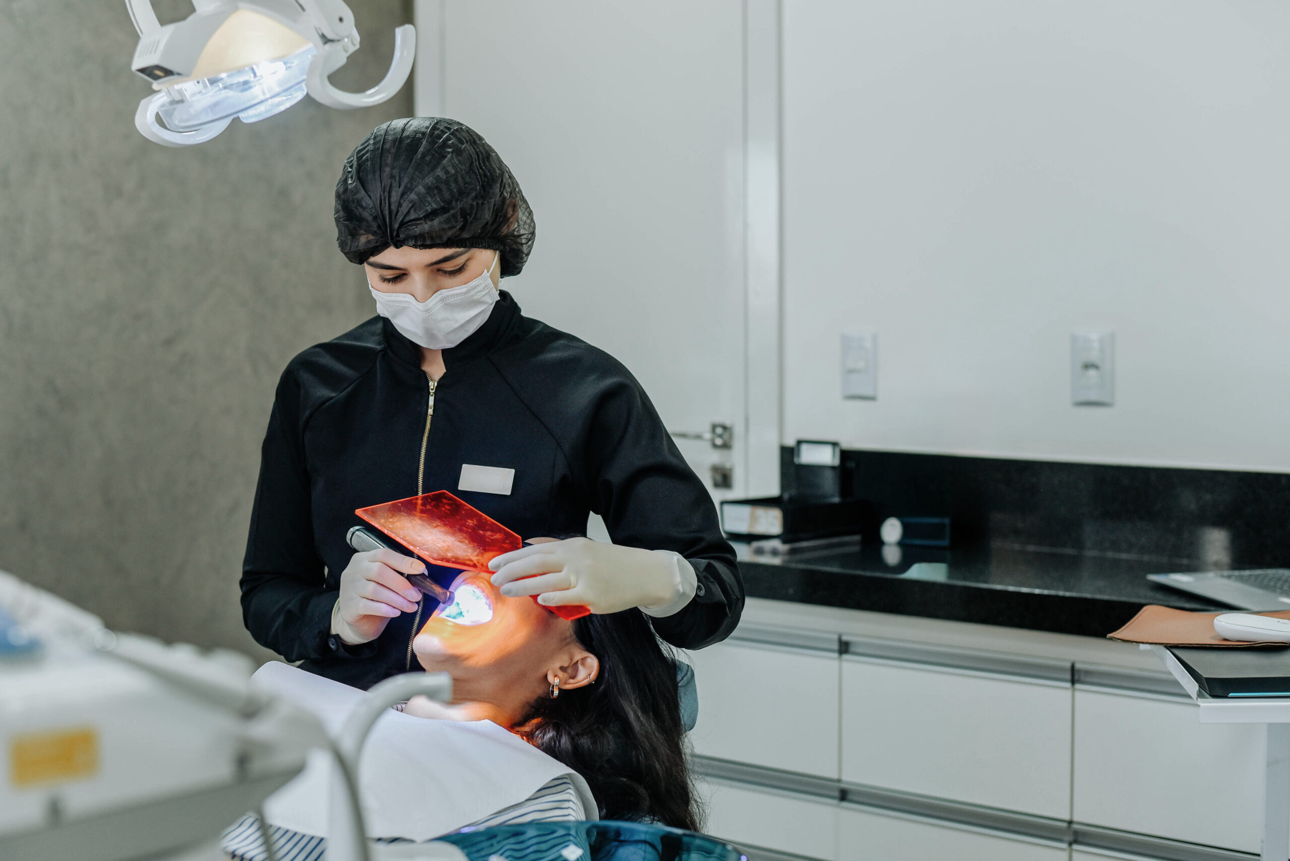 Dentist using an intraoral scanner to capture a digital impression during a dental procedure in a modern clinic.